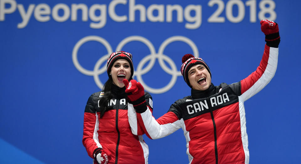 <p>Canada’s gold medallists Tessa Virtue (L) and Scott Moir celebrate on the podium during the medal ceremony for the figure skating ice dance at the Pyeongchang Medals Plaza during the Pyeongchang 2018 Winter Olympic Games in Pyeongchang on February 20, 2018. / AFP PHOTO / Fabrice COFFRINI (Photo credit should read FABRICE COFFRINI/AFP/Getty Images) </p>