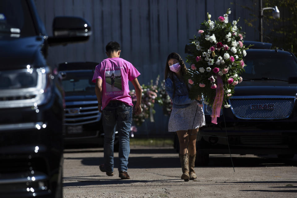 A person carries a flower arrangement from the funeral of Brianna Rodriguez , Saturday, Nov. 13, 2021, in Houston. Rodriguez died from injuries sustained during a stampede at the Astroworld music festival. (Marie D. De Jesús/Houston Chronicle via AP)