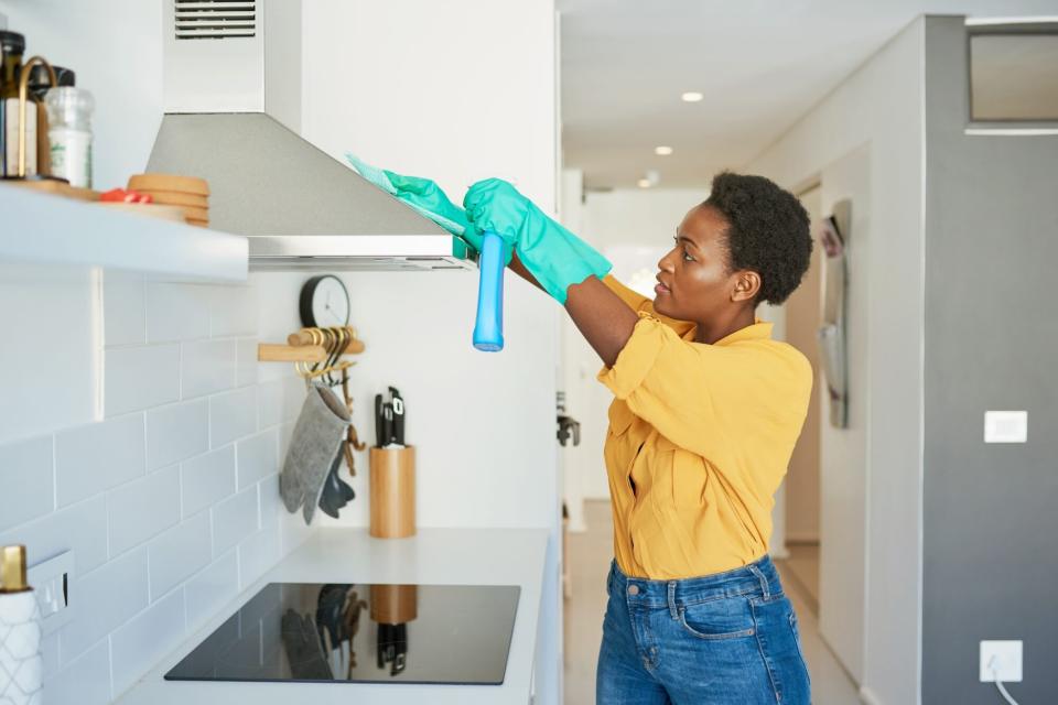 Woman cleaning kitchen range to prevent mold