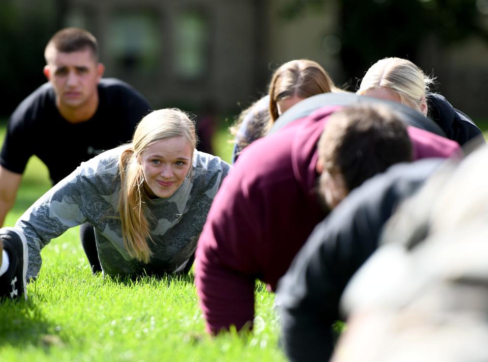 Walsh University freshman Kayla Lewis of Carrollton does 22 pushups Thursday in recognition of National Suicide Prevention Week. The university hosted active duty military members, students, faculty and staff who were asked to do 22 pushups to raise awareness of 22 veterans dying from suicide every day in the U.S.