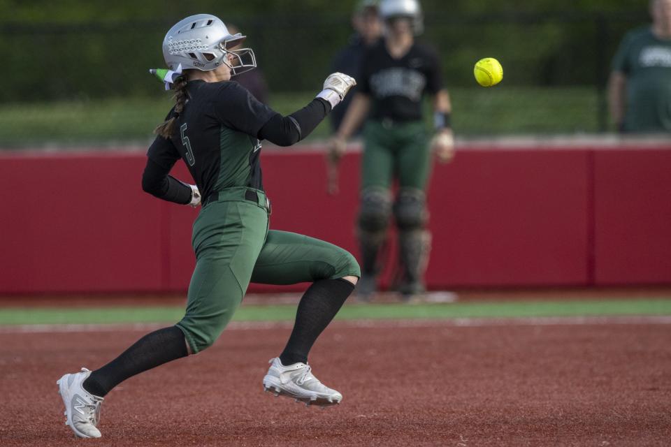 Zionsville High School junior Sylvia Mudis (5) races to third as the ball flies past her during an IHSAA softball game against New Palestine High School, Friday, April 19, 2024, at New Palestine High School. New Palestine won, 6-1.