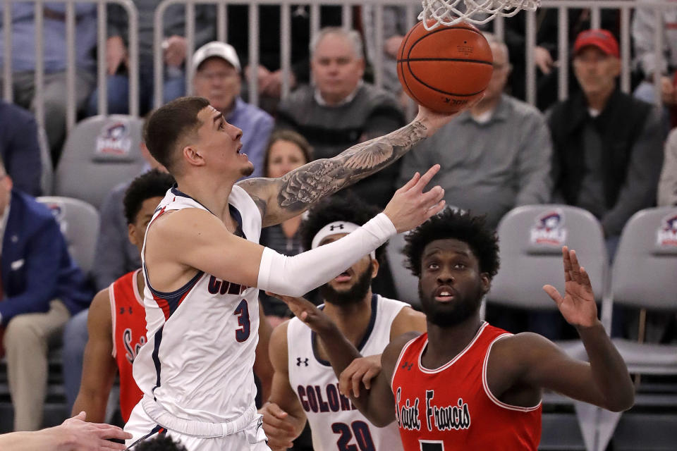 Robert Morris' Dante Treacy (3) takes a shot in front of St. Francis'sMyles Thompson, right, during the first half of an NCAA college basketball game for the Northeastern Conference men's tournament in Pittsburgh, Tuesday, March 10, 2020. (AP Photo/Gene J. Puskar)