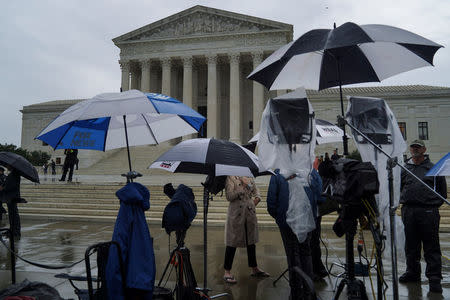 Television reporters wait prior to the U.S. Supreme Court's decision to impose limits on the ability of police to obtain cellphone data pinpointing the past location of criminal suspects, outside the U.S. Supreme Court in Washington, U.S., June 22, 2018. REUTERS/Toya Sarno Jordan