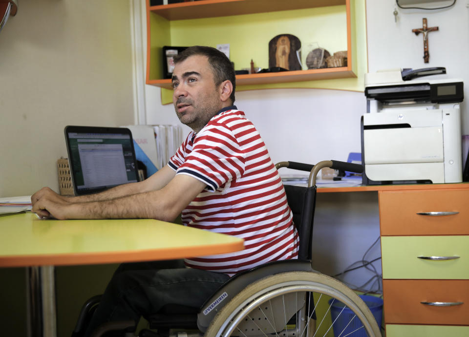 In this picture taken Tuesday, May 21, 2019, Marian Ilie, the man responsible for turning the village of Luncavita into an European Union money magnet, speaks during an interview with the Associated Press, in Luncavita, Romania. Ilie, who was preparing for the priesthood before a 2002 accident landed him in a wheelchair, found a new vocation as project manager for the use of EU funds allocated to his hometown. (AP Photo/Vadim Ghirda)