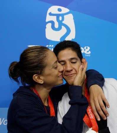 Silver medallist for the men's -68kg taekwondo competition Mark Lopez (R) of the U.S. and bronze medallist for the women's -57kg taekwondo competition Diana Lopez of the U.S. pose at the Beijing 2008 Olympic Games, August 21, 2008. REUTERS/Alessandro Bianchi/File Photo