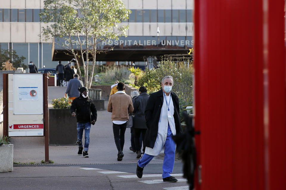 Dr. Philippe Montravers arrives at the main entrance of the Bichat Hospital, in Paris on Tuesday, Nov. 10, 2020. Montravers and the 150 doctors and nurses he leads have become experts about how to treat COVID-19. That knowledge is proving invaluable against a second deadly surge of the virus is again threatening to overwhelm European health systems. (AP Photo/Francois Mori)