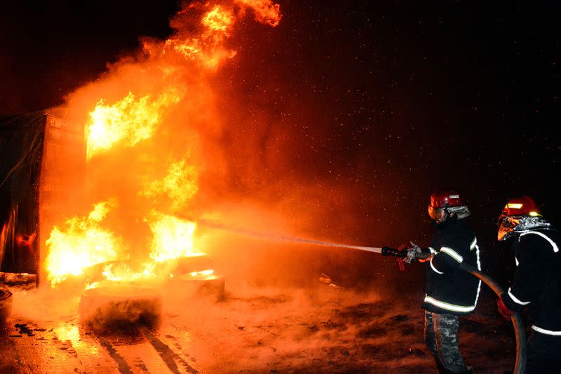 Firefighters douse flames after Syrian state media reported an Israeli missile attack in a container storage area, at Syrian port of Latakia