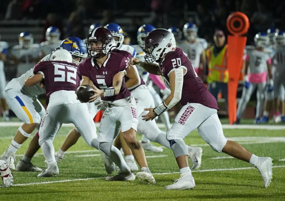 Harrison quarterback Dante Lanza (3) hands off to Chriatian Barchella (20) during their 18-0 win over Mahopac in Class A quarterfinal football action at Harrison High School in Harrison on Friday, October 27, 2023.