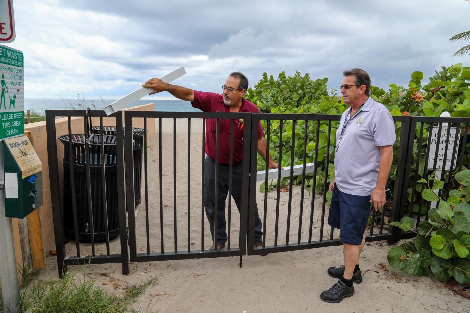 John Rivera, left, of Sunshine Safe and Lock and Town of Palm Beach project coordinator Warren Golde discuss plans Thursday for new lock on gate that allows access to the beach at the intersection of Root Trail and North Ocean Boulevard.