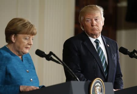 Germany's Chancellor Angela Merkel speaks as U.S. President Donald Trump looks on during their joint news conference in the East Room of the White House in Washington, U.S., March 17, 2017. REUTERS/Joshua_roberts