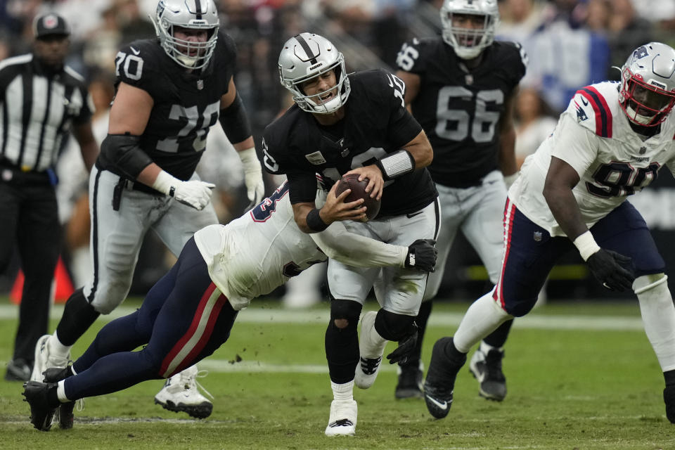 Las Vegas Raiders quarterback Jimmy Garoppolo, center, is hauled down by New England Patriots linebacker Anfernee Jennings during the first half of an NFL football game Sunday, Oct. 15, 2023, in Las Vegas. (AP Photo/John Locher)