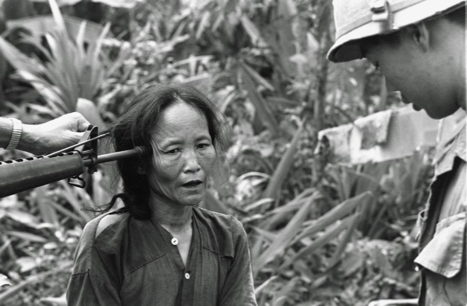 <p>Eine Frau in Vietnam wird von einem südvietnamesischen Polizisten befragt. Währenddessen wird ihr von einem US-Soldaten ein M16-Sturmgewehr an den Kopf gehalten. Auch dieses Foto aus dem Vietnamkrieg, aufgenommen im November 1967 von John Schneider, ist heute noch omnipräsent. (Bild: AP Photo/John Schneider) </p>