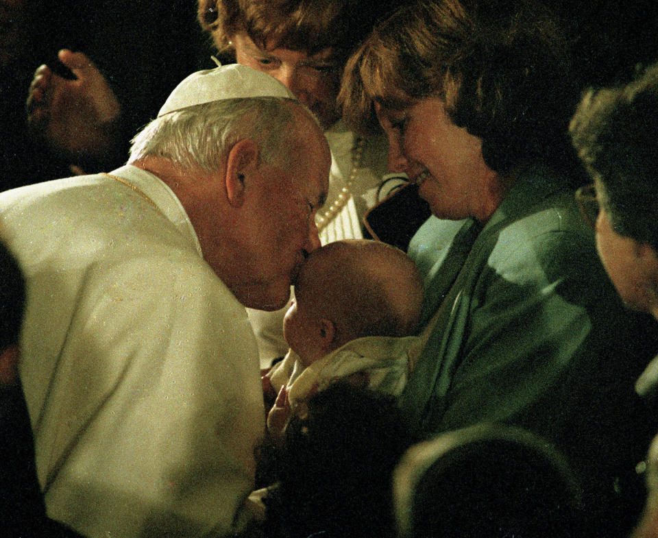 FILE - In this Sept. 15, 1987, photo taken by Associated Press photographer Leonard Ignelzi, Pope John Paul II kisses the forehead of an infant during a short prayer service at the Cathedral of Vibiana in Los Angeles. Ignelzi, whose knack for being in the right place at the right time produced breathtaking images of Hall of Fame sports figures, life along the U.S.-Mexico border, devastating wildfires and numerous other major news events over nearly four decades as a photographer for The Associated Press in San Diego, has died Friday, April 29, 2022. He was 74. (AP Photo/Lenny Ignelzi, File)