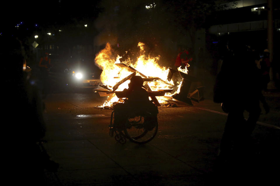 Protesters start a fire during in Portland, Ore., on Wednesday, Aug. 19, 2020. Protesters in Portland have clashed with federal agents for the first time since July in a demonstration that targeted a U.S. Immigration and Customs Enforcement building.(Sean Meagher/The Oregonian via AP)