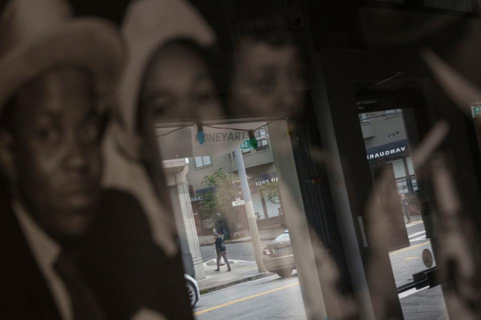 A window reflecting historic photos of the jazz scene at Honey Art Studio in the Fillmore district of San Francisco. 