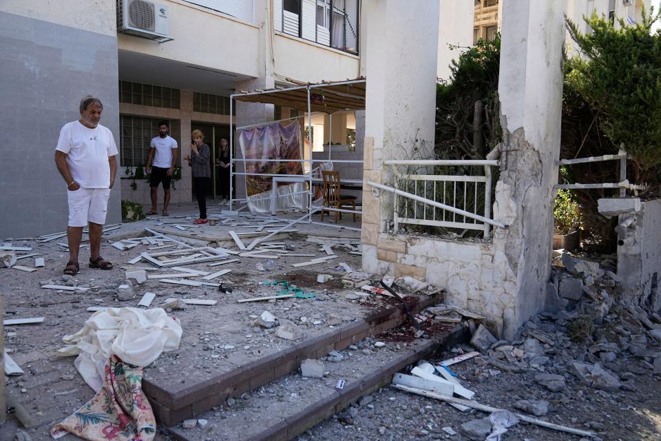 Residents look at damage after a rocket attack from the Gaza Strip in Ashkelon, Israel, on Saturday, Oct. 7, 2023. Palestinian militants in the Gaza Strip infiltrated Saturday into southern Israel and fired thousands of rockets into the country while Israel began striking targets in Gaza in response. 