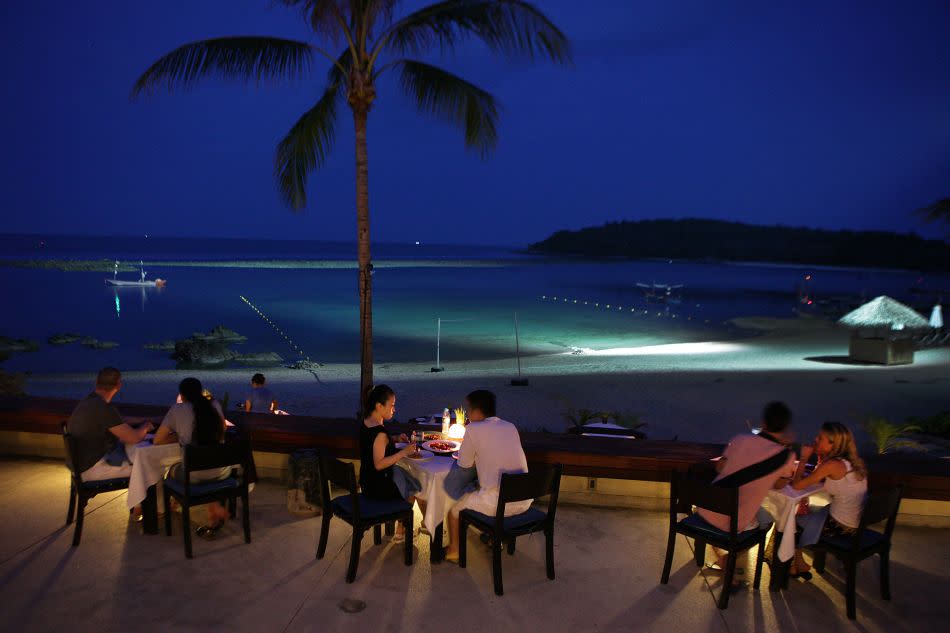 Tourists enjoy dinner along the water at the Anantara Lawana resort on Koh Samui.