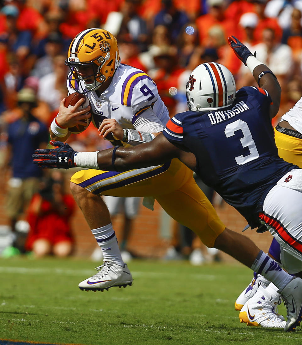 LSU quarterback Joe Burrow (9) carries the ball past Auburn defensive lineman Marlon Davidson (3) for the first down during the first half of an NCAA college football game, Saturday, Sept. 15, 2018, in Auburn, Ala. (AP Photo/Butch Dill)