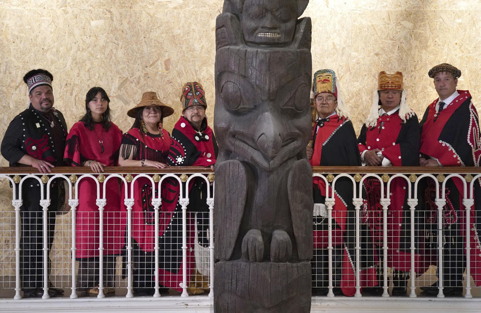 Earl Stephens, who has the Nisga'a cultural name Chief Ni'is Joohl, centre left, and members of the delegation from the Nisga'a nation pose beside the 11-metre tall memorial pole, during a visit to the National Museum of Scotland, in Edinburgh, Monday, Aug. 28, 2023. Members of a Canadian First Nation held a spiritual ceremony on Monday at a Scottish museum to begin the homeward journey of a totem pole stolen almost a century ago. The 11-meter (36-foot) pole is being restored by the National Museum of Scotland to the Nisga’a Nation in northern British Columbia — one of the first times a British museum has returned artifacts to North America’s Indigenous peoples. (Andrew Milligan/PA via AP)