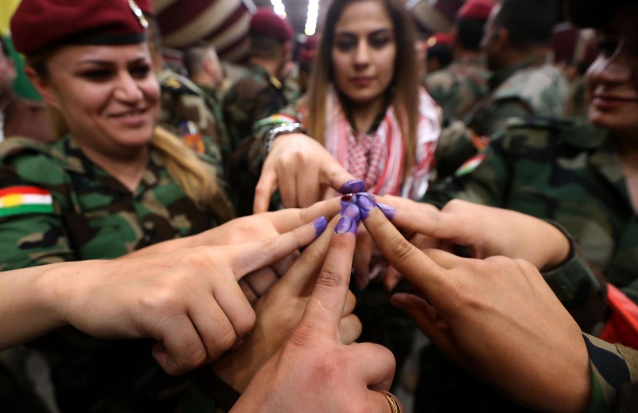 Women from a Kurdish Peshmerga battalion in Irbil show ink-stained fingers after casting their votes on Monday: AFP/Getty