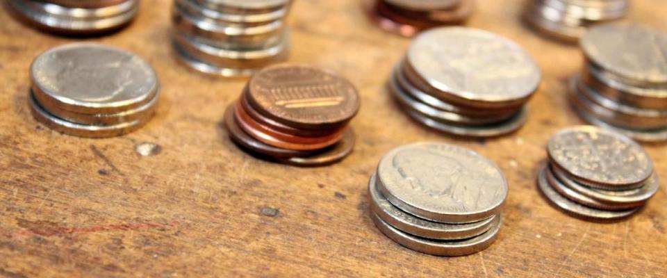 Pocket change, various coins over on old wood surface