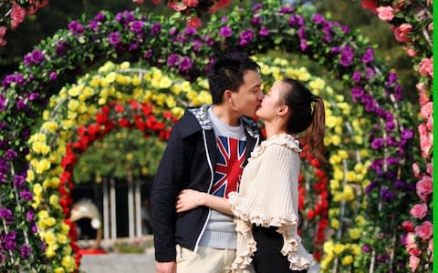 A couple kiss at Rose Garden of Yuntai Park, in Guangzhou, China. - Credit: ChinaFotoPress/Getty