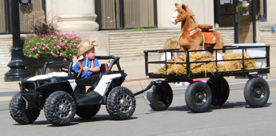 One cowboy checks on the welfare of his horse during the fair parade.