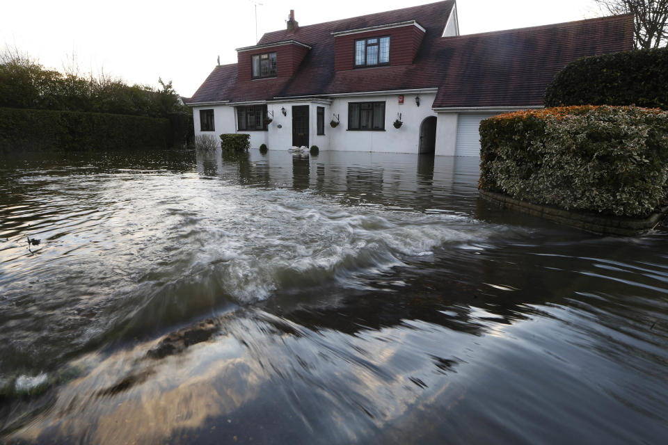 Water overflowing from the River Thames floods a house at Wraysbury, England, Monday, Feb. 10, 2014. The River Thames has burst its banks after reaching its highest level in years, flooding riverside towns upstream of London. Residents and British troops had piled up sandbags to protect properties from the latest bout of flooding, but the river overwhelmed their defenses Monday, leaving areas including the center of the village of Datchet underwater. (AP Photo/Sang Tan)