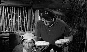 Gilligan stands up abruptly, knocking a pie into the Skipper's face