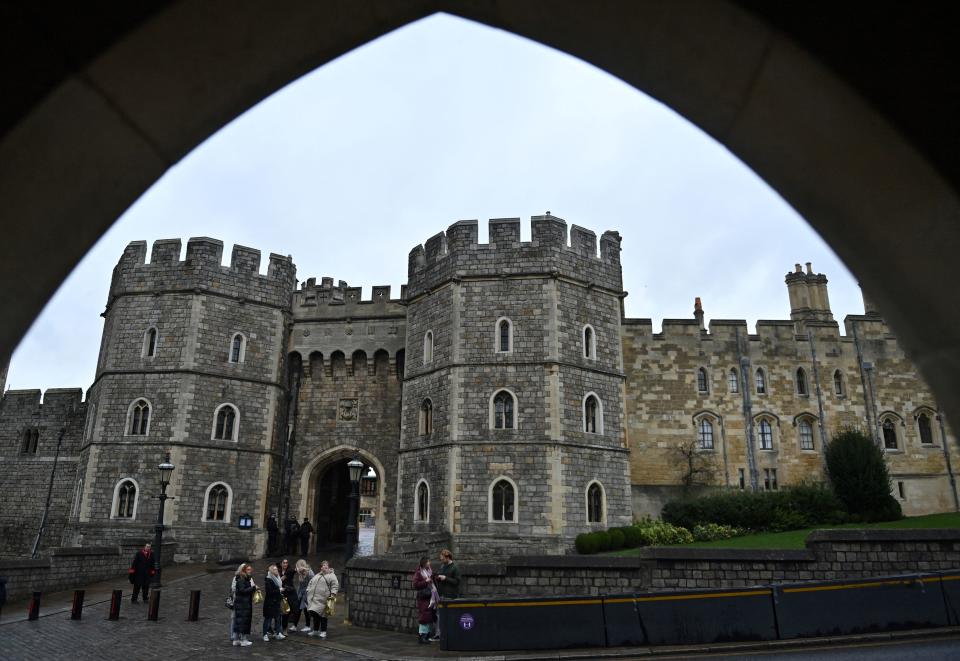 Visitors walk past Windsor Castle, main residence of Britain's Queen Elizabeth II, in Windsor, on February 20, 2022. - Britain's 95-year-old Queen Elizabeth II tested positive for Covid-19 on February 20, 2022, a fortnight after marking 70 years on the throne, but aides said her symptoms were 