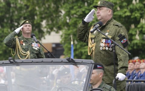 Igor Plotnitsky, head of the self-proclaimed Lugansk People's Republic, salutes during Victory Day military parade. - Credit: Alexander Ermochenko/Reuters