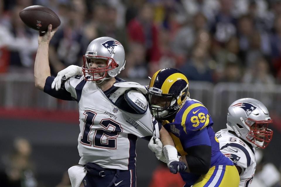 File-This Feb. 3, 2019 file photo shows New England Patriots' Tom Brady (12) passing under pressure form Los Angeles Rams' Aaron Donald (99) during the first half of the NFL Super Bowl 53 football game in Atlanta. Brady will soon slip on his sixth Super Bowl ring, and Herb Adderley is the only other man on the planet who can relate to that level of success as the National Football League celebrates its 100th season. "It's going to be a long time, another 100 years, before somebody wins himself six titles," said Adderley, the Hall of Fame cornerback for Vince Lombardi’s great Green Bay Packers teams of the 1960s. (AP Photo/Carolyn Kaster, File)