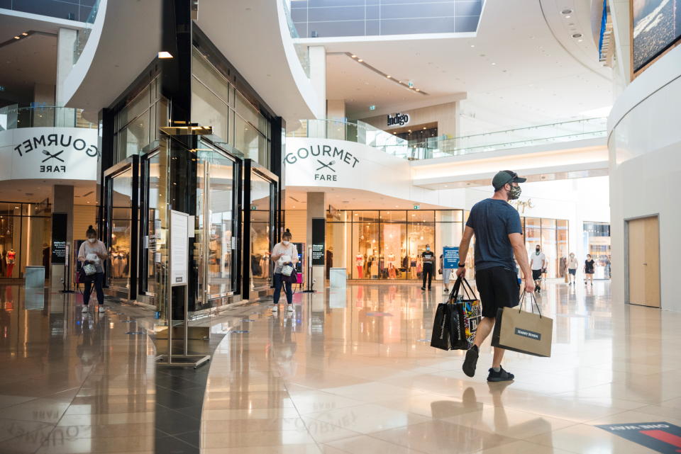 A shopper exits a store holding multiple shopping bags in Sherway Gardens mall during the stage two reopening from coronavirus disease (COVID-19) restrictions in Toronto, Ontario, Canada June 30, 2021. REUTERS/Alex Filipe