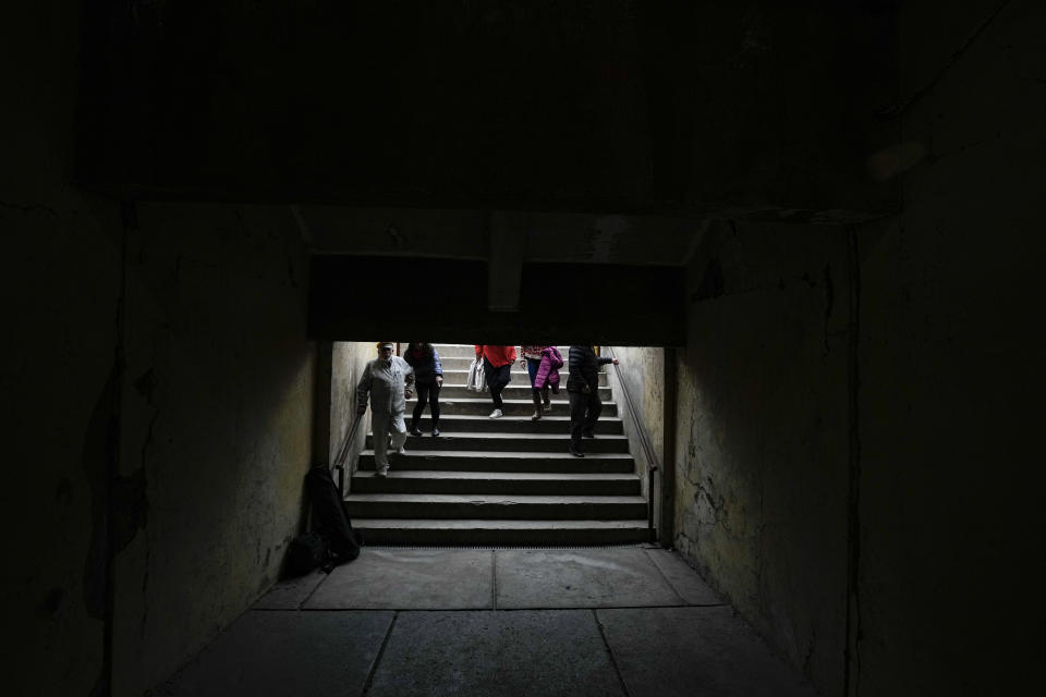 FILE - Jaime Zorondo, left, accompanied by relatives, descends the stairs that lead to a tunnel at the National Stadium that was once used as a prison and place of torture during the 1973 coup, in Santiago, Chile, Saturday, Sept. 2, 2023. Zorondo, who was detained at the stadium, said inmates could only eat whatever they found on the floor at the stadium. “We ate orange peelings, eggs that had been stepped on, anything we could see." (AP Photo/Esteban Felix, File)