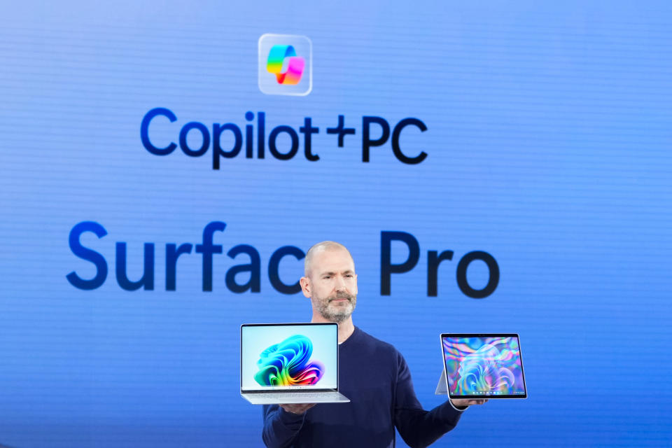 Brett Ostrum, Microsoft corporate vice president of Surface, holds up the new Surface Laptop and Surface Pro with built-in AI hardware during a showcase event of the company's AI assistant, Copilot, at Microsoft headquarters, Monday, May 20, 2024, in Redmond, Wash. (AP Photo/Lindsey Wasson)