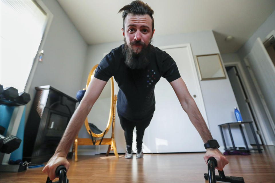 In this Friday, March 13, 2020 photo, Nic Talbott does pushups during one of his workouts in his continuing hopes of being permitted to enlist inn the armed forces at his home in Lisbon, Ohio. Talbott is a plaintiff in one of four lawsuits filed in federal courts challenging a Trump administration policy barring transgender Americans from enlisting in the military. (AP Photo/Keith Srakocic)