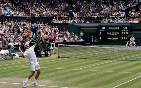 Switzerland's Roger Federer, left, serves to Serbia's Novak Djokovic, right, during the men's singles final match of the Wimbledon - Credit: AP