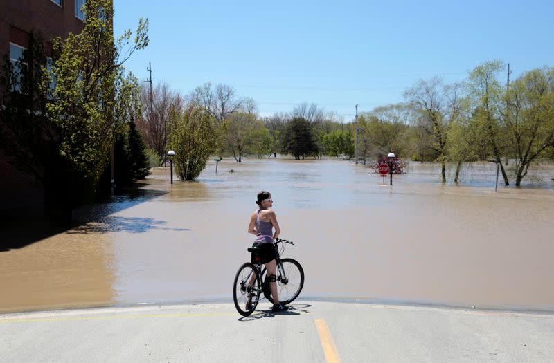 A resident looks at a flooded street along the Tittabawassee River, after several dams breached, in downtown Midland