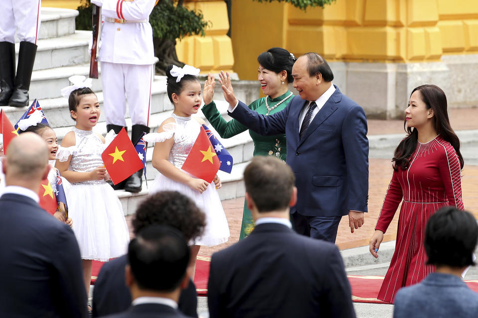 Vietnamese Prime Minister Nguyen Xuan Phuc, accompanied by his wife Tran Nguyet Thu, third from right, arrives for a welcome ceremony for visiting Australian Prime Minister Scott Morrison at the Presidential Palace in Hanoi, Vietnam, Friday, Aug. 23, 2019. Morrison is on a three-day official visit to Vietnam. (AP Photo/Duc Thanh)