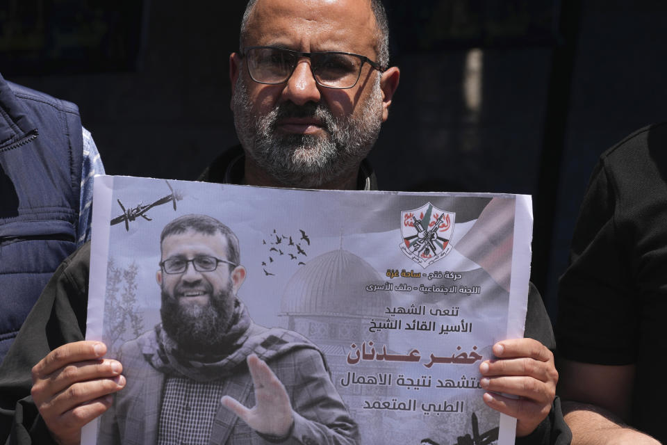 A Palestinian holds a picture of Khader Adnan, a leader in the militant Islamic Jihad group, who died in Israeli prison after a nearly three-month hunger strike, during a sit-in in front of the International Committee of the Red Cross office, in Gaza City, Tuesday, May 2, 2023. Arabic on a picture reads " Fatah mourns the martyr, prisoner and leader Khader Adnan, was killed due to deliberate medical negligence." Adnan had begun staging protracted hunger strikes more than a decade ago, introducing a new form of protests against Israel's mass detentions of Palestinians without charges or trials. (AP Photo/Adel Hana)