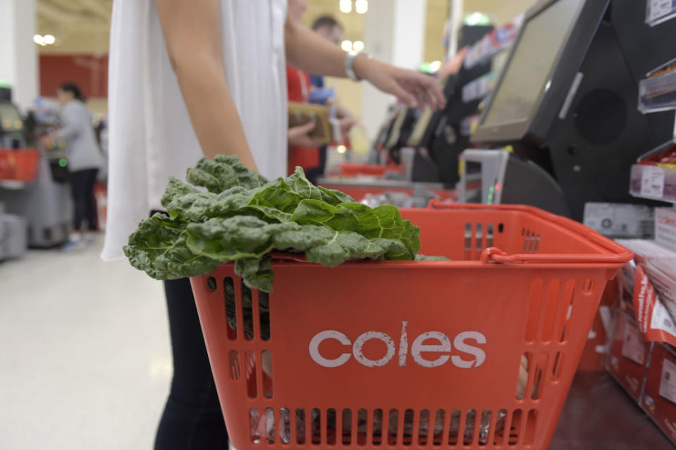 A customer uses a self checkout at Coles. 