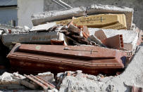 <p>Coffins covered by debris are seen in a cemetery following an earthquake at Sant’ Angelo near Amatrice, central Italy, Aug. 26, 2016. (Photo: Max Rossi/Reuters) </p>