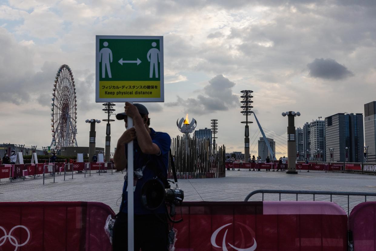 A man holds a notice requesting that people observe social distancing in Tokyo (Getty Images)