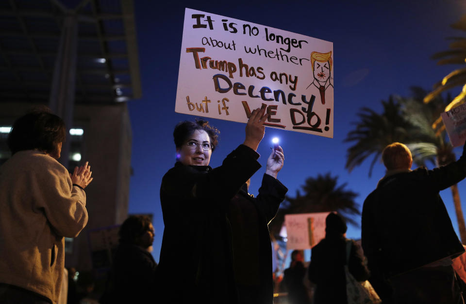 Alisa McAffee holds up a sign during a demonstration in support of special counsel Robert Mueller, Thursday, Nov. 8, 2018, in Las Vegas. (AP Photo/John Locher)