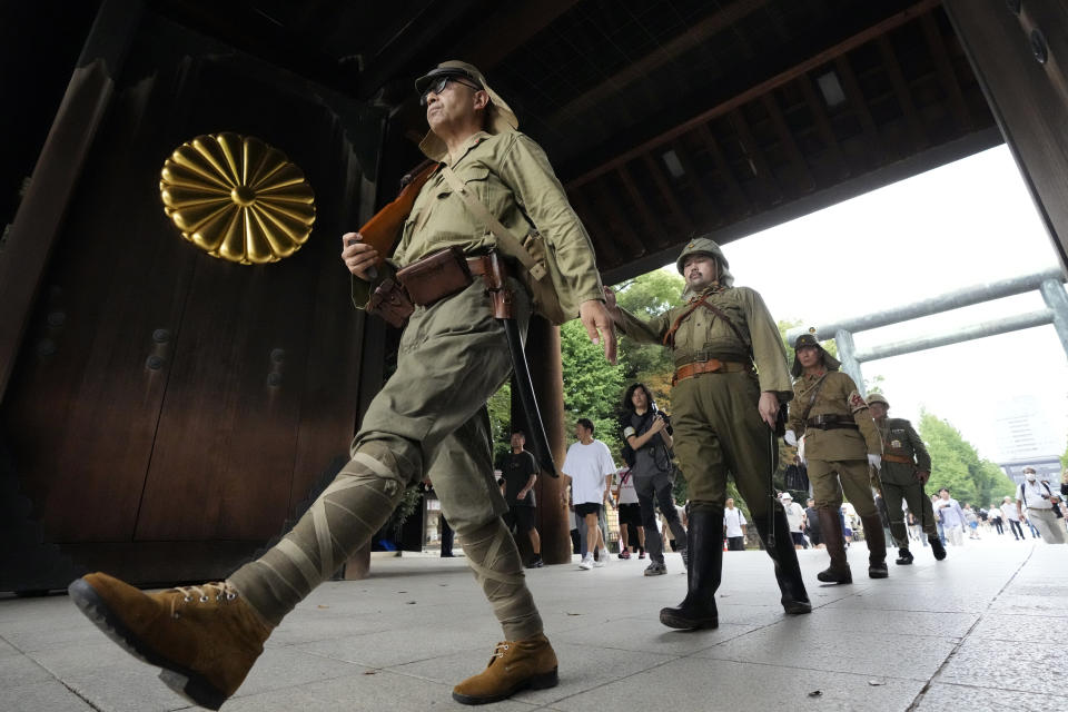 Visitors in Japanese Imperial army costume enter the Yasukuni Shrine, which honors Japan's war dead, Tuesday, Aug. 15, 2023, in Tokyo, Japan. Japan holds annual memorial service for the war dead as the country marks the 78th anniversary of its defeat in the World War II. (AP Photo/Eugene Hoshiko)