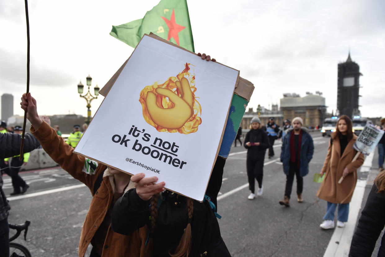 LONDON, ENGLAND - FEBRUARY 14: Students march on Westminster Bridge holding a placard saying "It's not OK boomer" during the "Fridays for Future" climate change rally on February 14, 2020 in London, England. The youth strike movement to demand action on climate change started in August 2018, led by the Swedish teenager Greta Thunberg. (Photo by John Keeble/Getty Images)