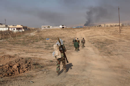 Peshmerga forces carry weapons near the town of Bashiqa, east of Mosul, during an operation to attack Islamic State militants in Mosul, Iraq, November 7, 2016. REUTERS/Azad Lashkari