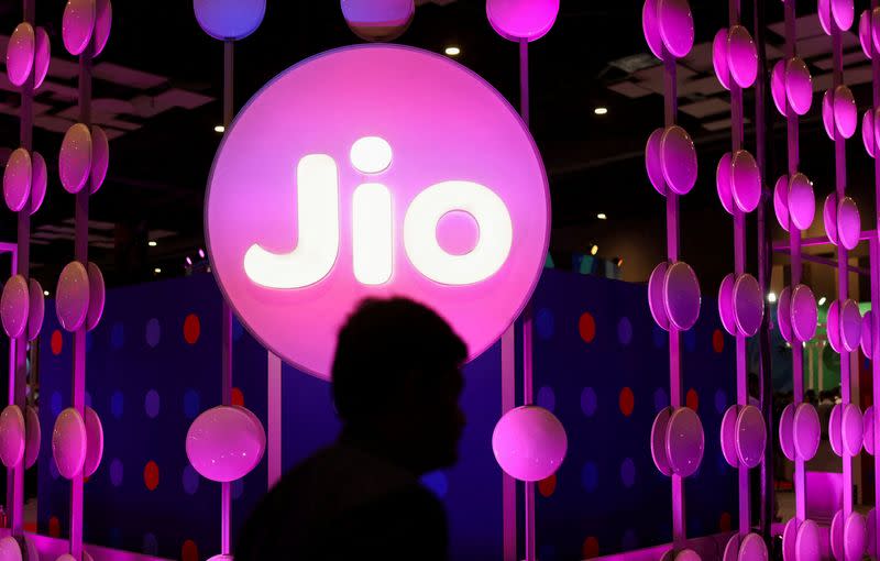 FILE PHOTO: A man walks across the LED board showing the logo of Jio at the ongoing India Mobile Congress 2022, at Pragati Maidan, in New Delhi