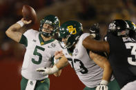 FILE - In this Nov. 7, 2020, file photo, Baylor quarterback Charlie Brewer throws a pass as offensive lineman Jake Burton, center, holds back Iowa State defensive end JaQuan Bailey during the second half of an NCAA college football game in Ames, Iowa. Brewer is set for his 25th consecutive start as Baylor’s quarterback, and 37th overall, when Baylor plays Kansas State this week. (AP Photo/Matthew Putney, File)