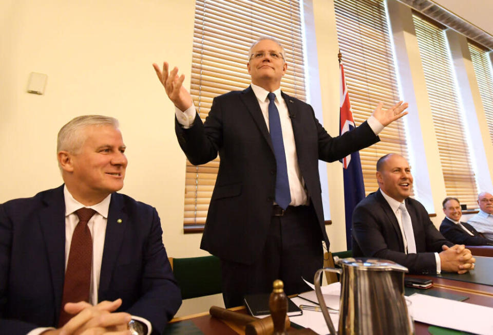 CANBERRA, AUSTRALIA - MAY 28: Prime Minister Scott Morrison (C) waves to his ministers with the Deputy Prime Minister Michael McCormack (L) and  Deputy Leader of the Liberal Party Josh Frydenberg (R) during a Joint Party Room meeting at Parliament House on May 28, 2019 in Canberra, Australia. Scott Morrison's new ministry will be sworn in tomorrow following his victory in the May 18 Federal election.  (Photo by Tracey Nearmy/Getty Images)